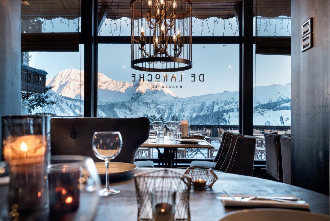 Tables dressées au restaurant De Laroche au Courcheneige avec vue sur les montagnes enneigées