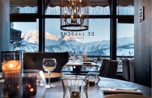 Tables dressées au restaurant De Laroche au Courcheneige avec vue sur les montagnes enneigées