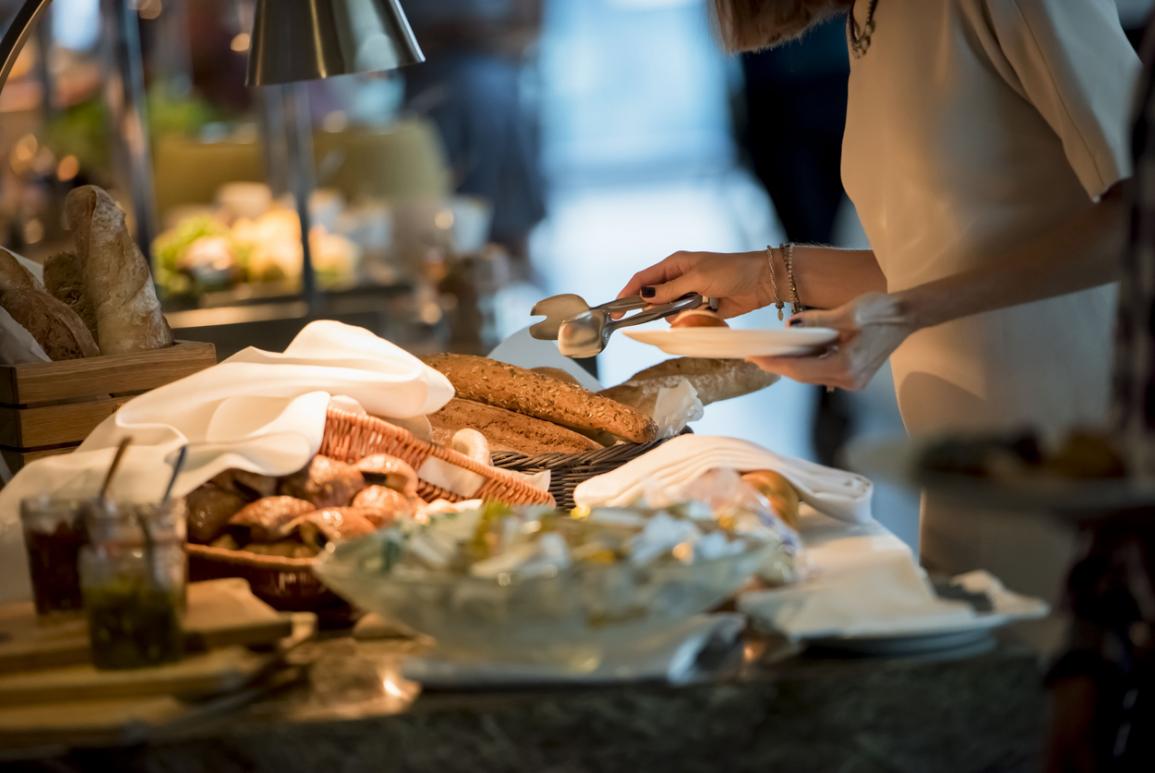 Une femme qui se sert sur le buffet du petit-déjeuner de l'hôtel Courcheneige