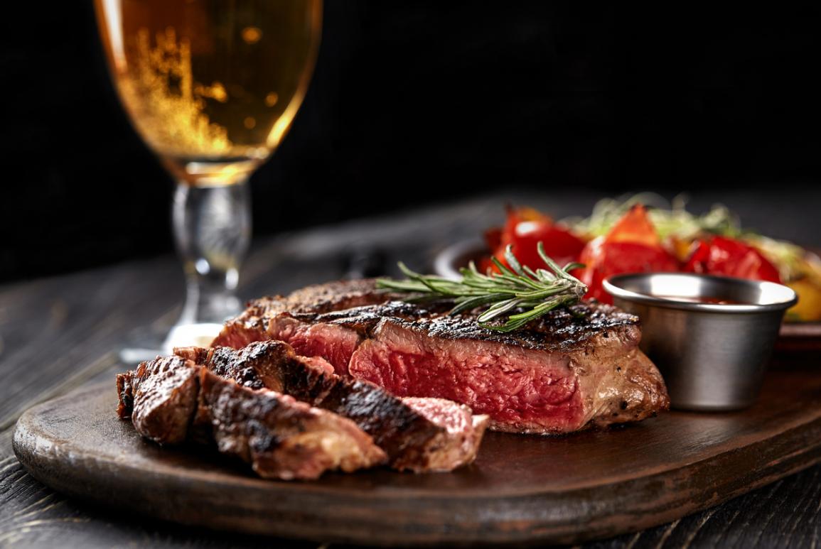 Assiette d'une pièce de bœuf avec un verre de bière au restaurant du Courcheneige