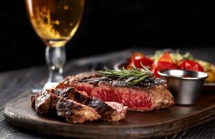 Assiette d'une pièce de bœuf avec un verre de bière au restaurant du Courcheneige