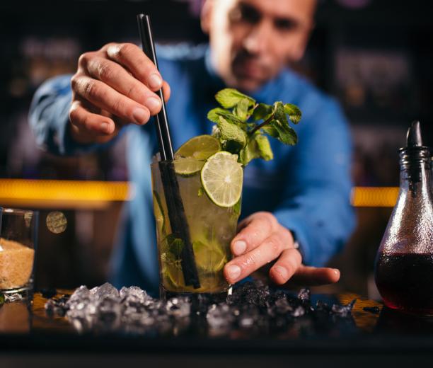 Barman qui prépare un cocktail derrière le Grrizzly Bar à Courchevel