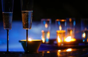 Coupes de champagne et bougies sur une table du restaurant du Courcheneige et vue sur l'extérieur pendant la nuit