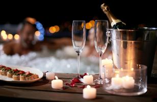 Dîner romantique au Courcheneige avec deux coupes de champagne, des petits toasts, des bougies et des pétales de rose