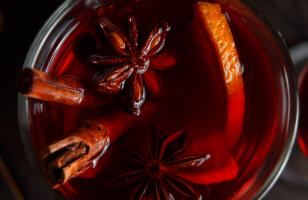 Gros plan sur un cocktail dans un verre avec des tiges de cannelles et une tranche d'orange au Courcheneige