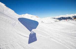 Ombre d'une montgolfière dans la neige à Courchevel