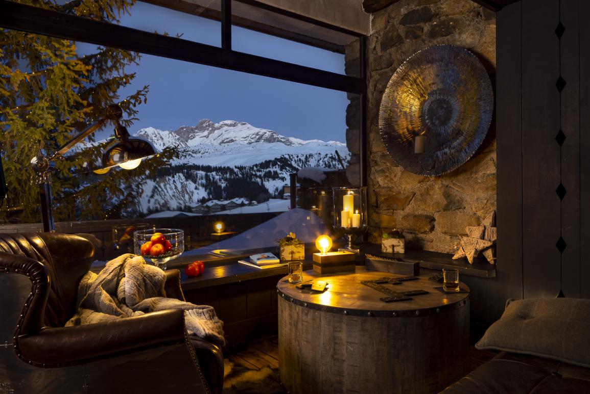 Terrasse du Grrizzly Bar à Courchevel le soir avec vue sur la montagne enneigée