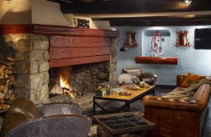 Salon avec cheminée et canapé en cuir de l'hôtel Courcheneige à Courchevel