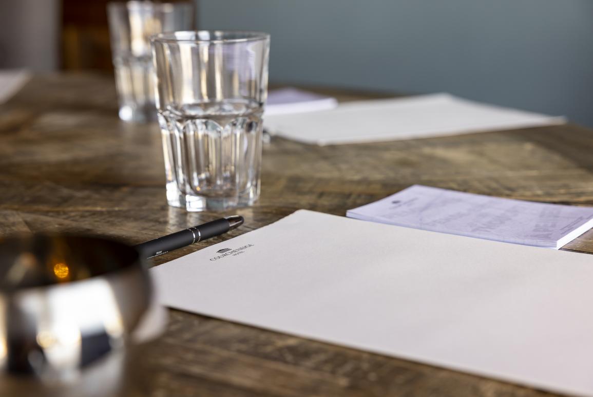 Gros plan sur un bloc note et un stylo sur une table lors d'un séminaire à l'hôtel Courcheneige