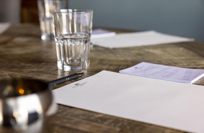 Gros plan sur un bloc note et un stylo sur une table lors d'un séminaire à l'hôtel Courcheneige