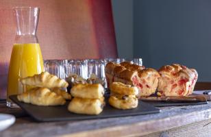 Viennoiseries, jus d'orange et verres sur le buffet du petit-déjeuner du Courcheneige