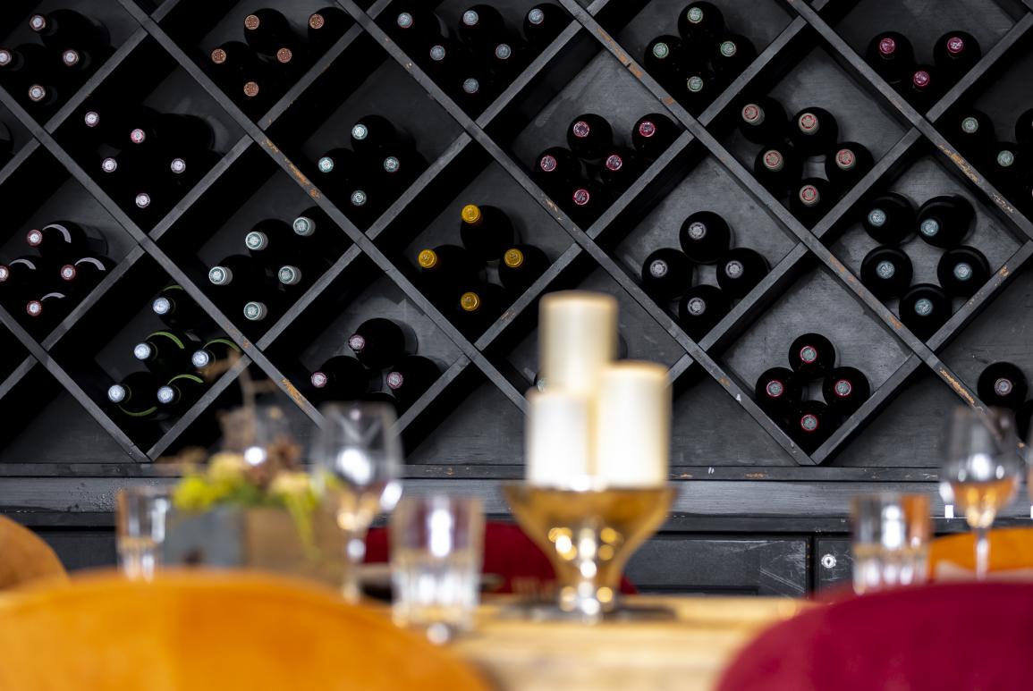 Meuble rempli de bouteilles de vin dans la salle du restaurant du Courcheneige