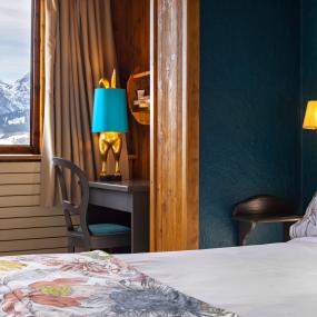 Lit et bureau de la chambre familiale est du Courcheneige, hôtel à Courchevel, France