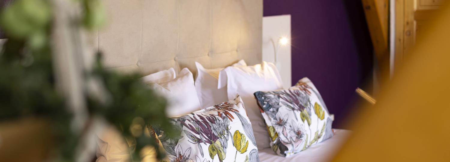 Plan rapproché d'un lit double dans une chambre de l'hôtel Courcheneige à Courchevel